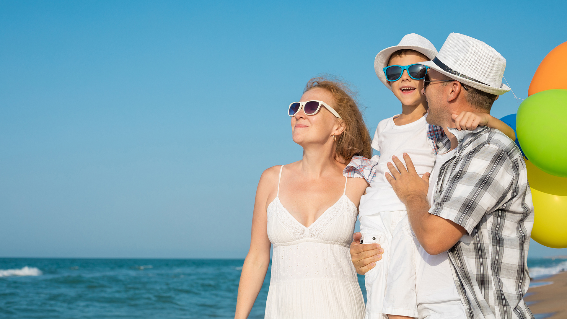 Father mother and son playing on the beach at the day time.
